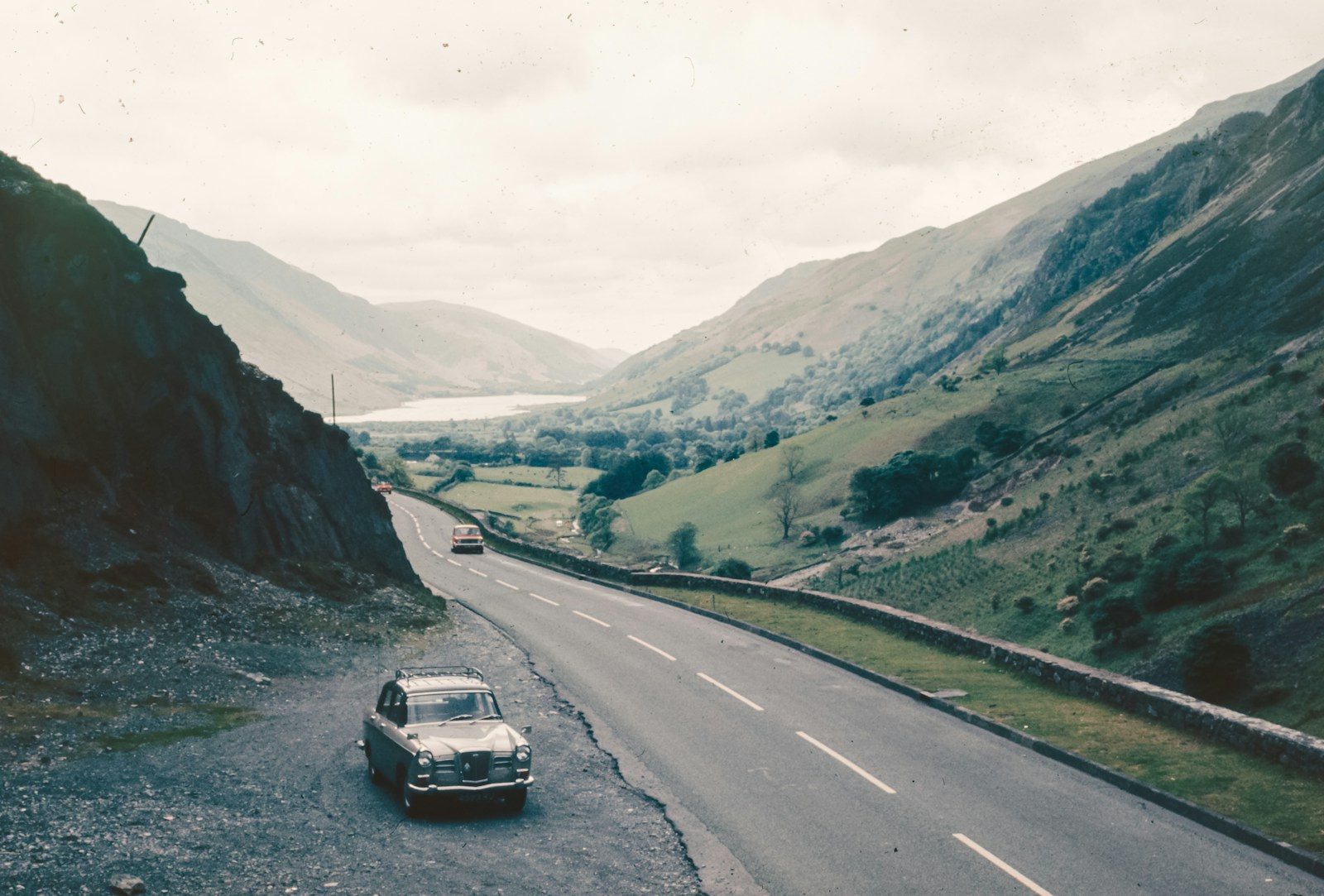 A car driving down a road in the mountains